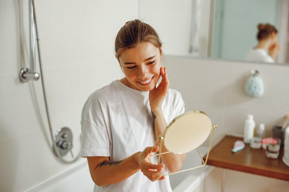 mujer mirándose al espejo en el cuarto de baño