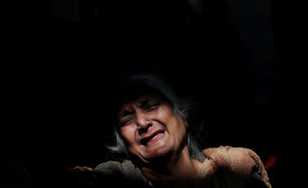 A woman cries next to the burning pyre of a family member who died after a commuter train traveling at high speed ran through a crowd of people on the rail tracks on Friday, at a cremation ground in Amritsar, India, October 20, 2018. REUTERS/Adnan Abidi TPX IMAGES OF THE DAY