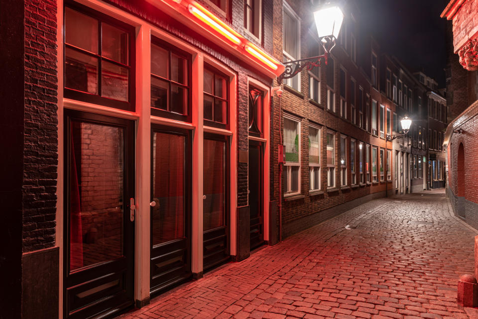 A quiet, deserted street in a city's red-light district at night