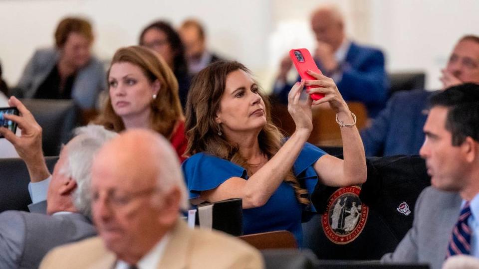Rep. Tricia Cotham, a Mecklenburg County Republican, points her phone towards the gallery prior to veto override votes in the House at the General Assembly in Raleigh on Wednesday, Aug 16, 2023.