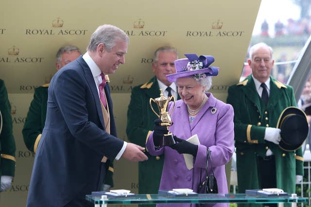 The Duke of York presents the Queen with a trophy 