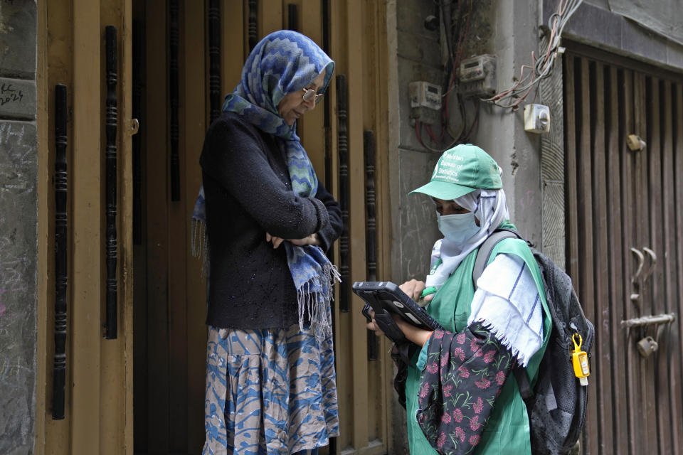 A government worker collects data from a woman during census, in Lahore, Pakistan, Wednesday, March 1, 2023. Pakistan on Wednesday launched its first-ever digital population and housing census to gather demographic data on every individual ahead of the parliamentary elections which are due later this year, officials said. (AP Photo/K.M. Chaudary)