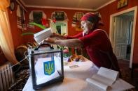 A local resident casts her vote into a mobile ballot box during Ukraine's parliamentary election in Kiev Region