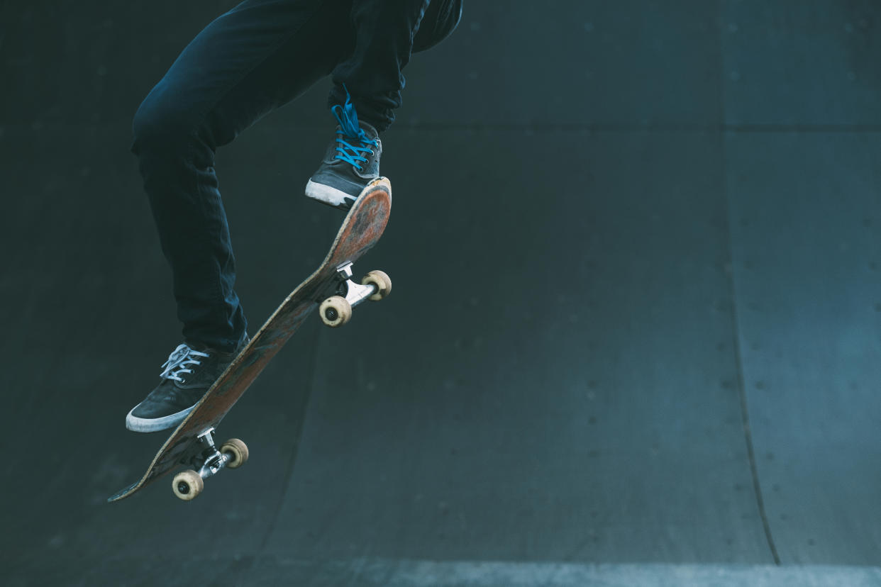 Urban skater in action. Ollie trick. Skate park ramp. City area. Man on skateboard jumping. Copy space for text.