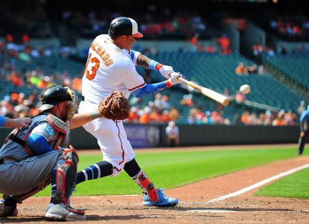 Jun 17, 2018; Baltimore, MD, USA; Baltimore Orioles shortstop Manny Machado (13) hits an RBI single in the eighth inning against the Miami Marlins at Oriole Park at Camden Yards. Mandatory Credit: Evan Habeeb-USA TODAY Sports