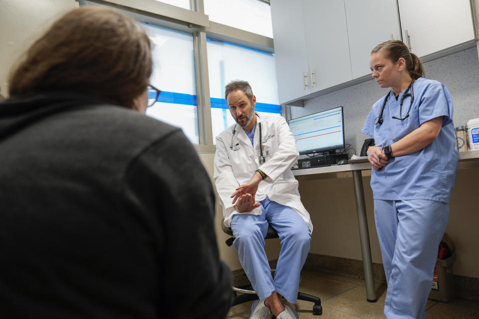 Senior veterinarian Dr. Daniel Spector, center, explains to Jennie Anne Simson, left, the surgery he will perform on the foster cat Lynx during a consultation at the Schwarzman Animal Medical Center, Friday, March 8, 2024, in New York. (AP Photo/Mary Altaffer)