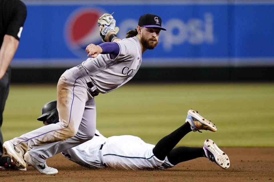 Colorado Rockies second baseman Brendan Rodgers looks for the call after tagging out Arizona Diamondbacks' Ketel Marte on a steal attempt during the fourth inning of a baseball game Thursday, July 7, 2022, in Phoenix. (AP Photo/Ross D. Franklin)