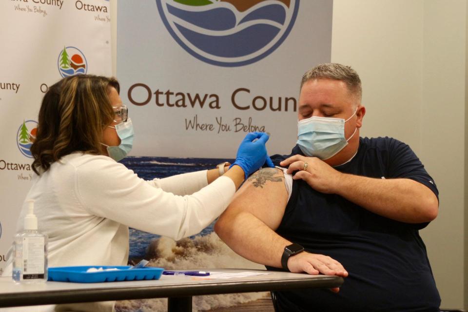Ottawa County Department of Public Health immunization nurse Robin Schurman administers the Pfizer/BioNTech COVID-19 vaccine to Jeff Potter, Zeeland firefighter and EMT, on Dec. 18, 2020, at Grand Valley State University's Holland. Ottawa County published its annual disease report for 2021 this month, showing several trends in communicable diseases in the county.