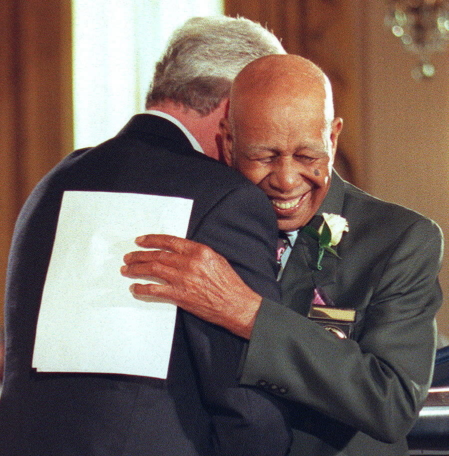 Ernest Hendon, last surviving participant in the Tuskegee syphilis study, embraces President Bill Clinton