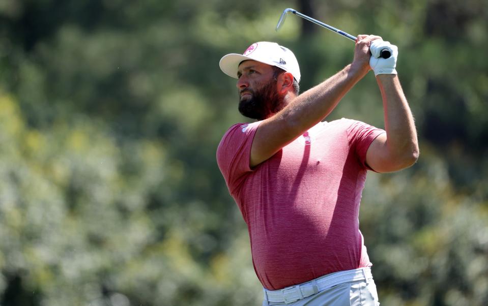 Jon Rahm plays a shot on the first hole