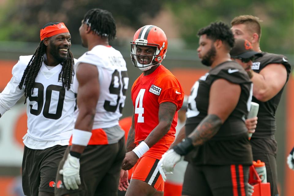 Cleveland Browns quarterback Deshaun Watson, center, shares a laugh with defensive ends Jadeveon Clowney, left, and Myles Garrett, left center, during the NFL football team's football training camp in Berea on Monday.