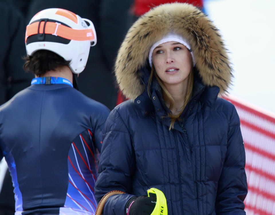 Morgan Miller, wife of United States' Bode Miller, holds her husband's ski poles after he finished the slalom portion of the men's super combined at the Sochi 2014 Winter Olympics, Friday, Feb. 14, 2014, in Krasnaya Polyana, Russia. (AP Photo/Gero Breloer)