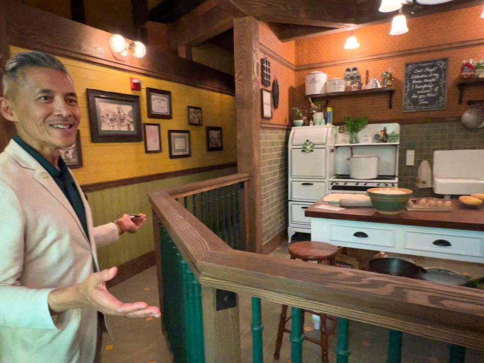 Disney creative executive Ted Robledo points out details in the queue for Tiana's Bayou Adventure, like the recipe for Tiana's famous beignets and her dad's gumbo pot under the kitchen table.