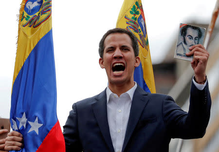 FILE PHOTO: Juan Guaido, President of Venezuela's National Assembly, holds a copy of Venezuelan constitution during a rally against Venezuelan President Nicolas Maduro's government and to commemorate the 61st anniversary of the end of the dictatorship of Marcos Perez Jimenez in Caracas, Venezuela January 23, 2019. REUTERS/Carlos Garcia Rawlins/File Photo