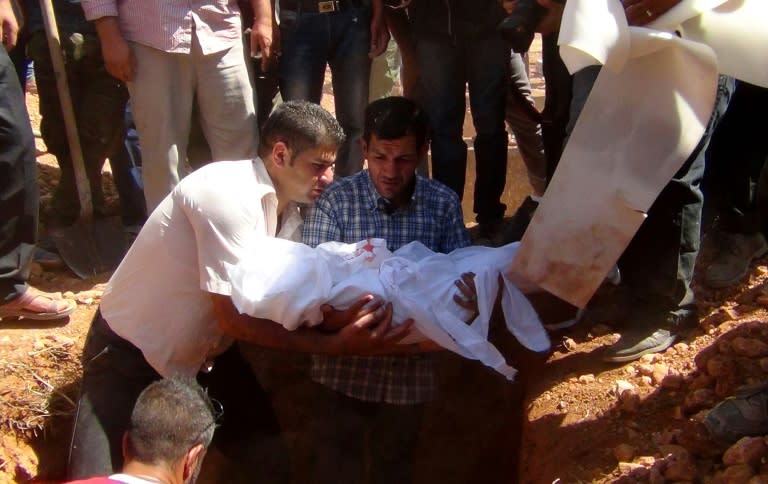 The father of toddler Aylan Kurdi, whose lifeless body on a Turkish beach became a symbol of the refugee crisis, holds the body of his child during a funeral ceremony in Kobane, Syria, on September 4, 2015