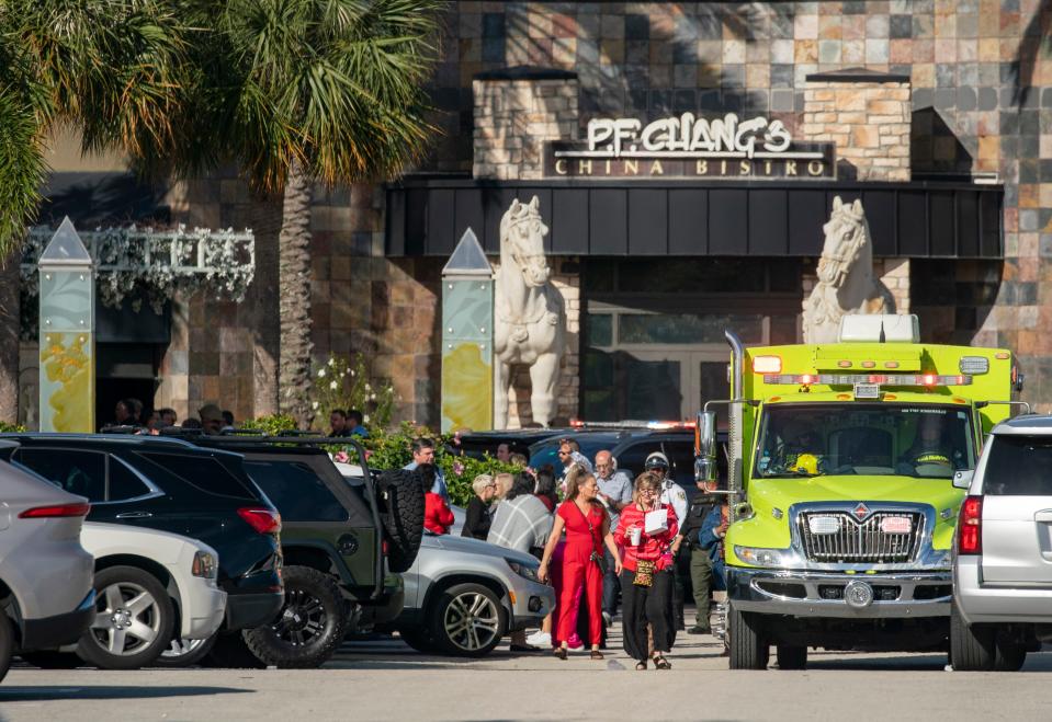 People wait in the parking lot outside The Gardens Mall after a shooting in the mall on February 14, 2024, in Palm Beach Gardens, Florida.