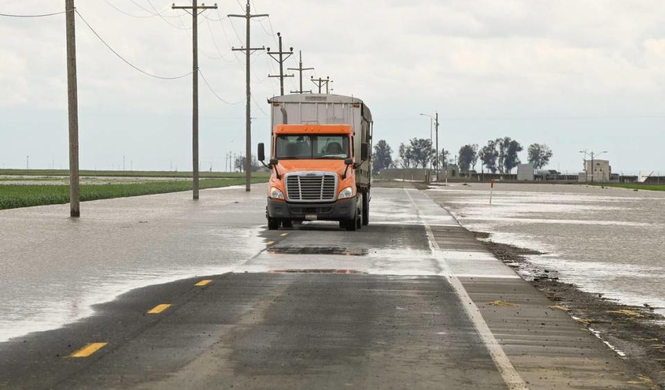 A truck drives through a flooded road in Kings County south of Hanford on Thursday, March 23, 2023.