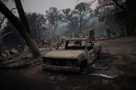 The remains of a vehicle and home are seen in the aftermath of the Glass Fire in Deer Park, California