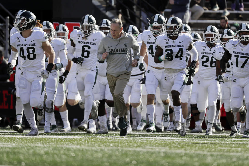 Michigan State head coach Mark Dantonio leads his team on to the field to face Rutgers in an NCAA college football game Saturday, Nov. 23, 2019, in Piscataway, N.J. Michigan State won 27-0. (AP Photo/Adam Hunger)