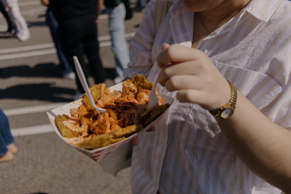 Sofía Viera, center, enjoys a plate of Puerto Rican nachos from Latin Bites.