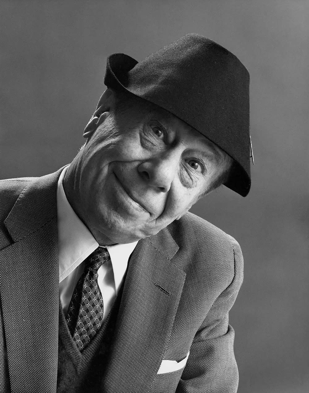 Bert Lahr smiling in a suit wearing a fedora.