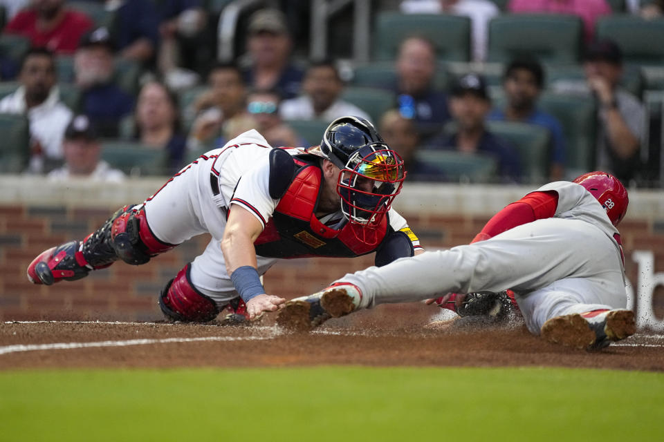 St. Louis Cardinals' Nolan Arenado, right, beats the tag from Atlanta Braves catcher Sean Murphy (12) as he scores on a double by Jordan Walker in the second inning of a baseball game Tuesday, Sept. 5, 2023, in Atlanta. (AP Photo/John Bazemore)