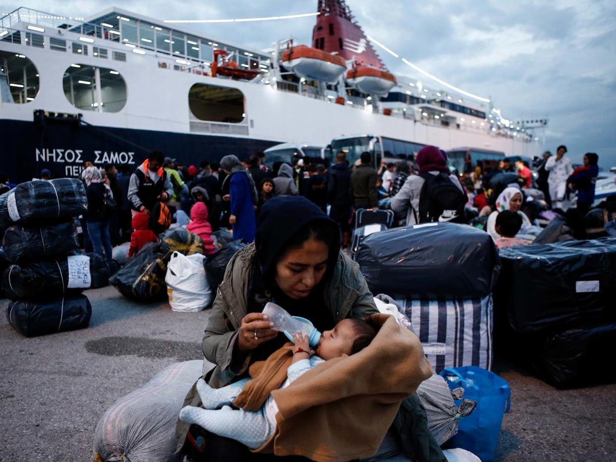 A woman feeds her baby after disembarking from the ferry 'Nissos Samos' upon her arrival from Lesvos island to the port of Piraeus, Greece. EPA/YANNIS KOLESIDIS: EPA