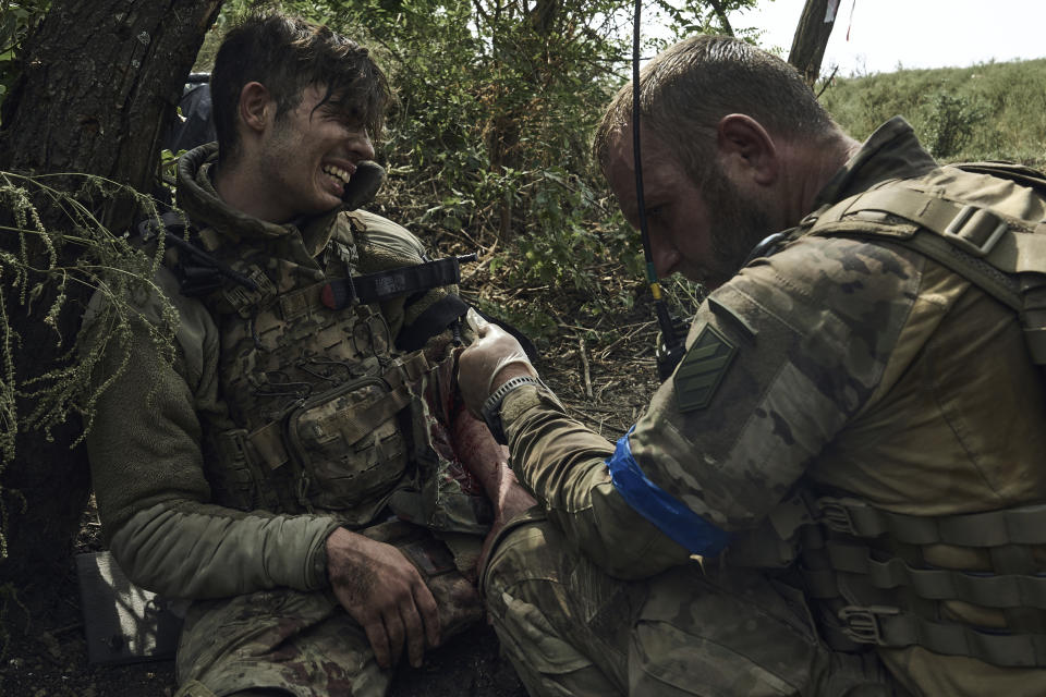 A soldier of Ukraine's 3rd Separate Assault Brigade gives first aid to his wounded comrade, call sign Polumya (Flame), 19, near Bakhmut, the site of fierce battles with the Russian forces in the Donetsk region, Ukraine, Monday, Sept. 4, 2023. (AP Photo/Libkos)