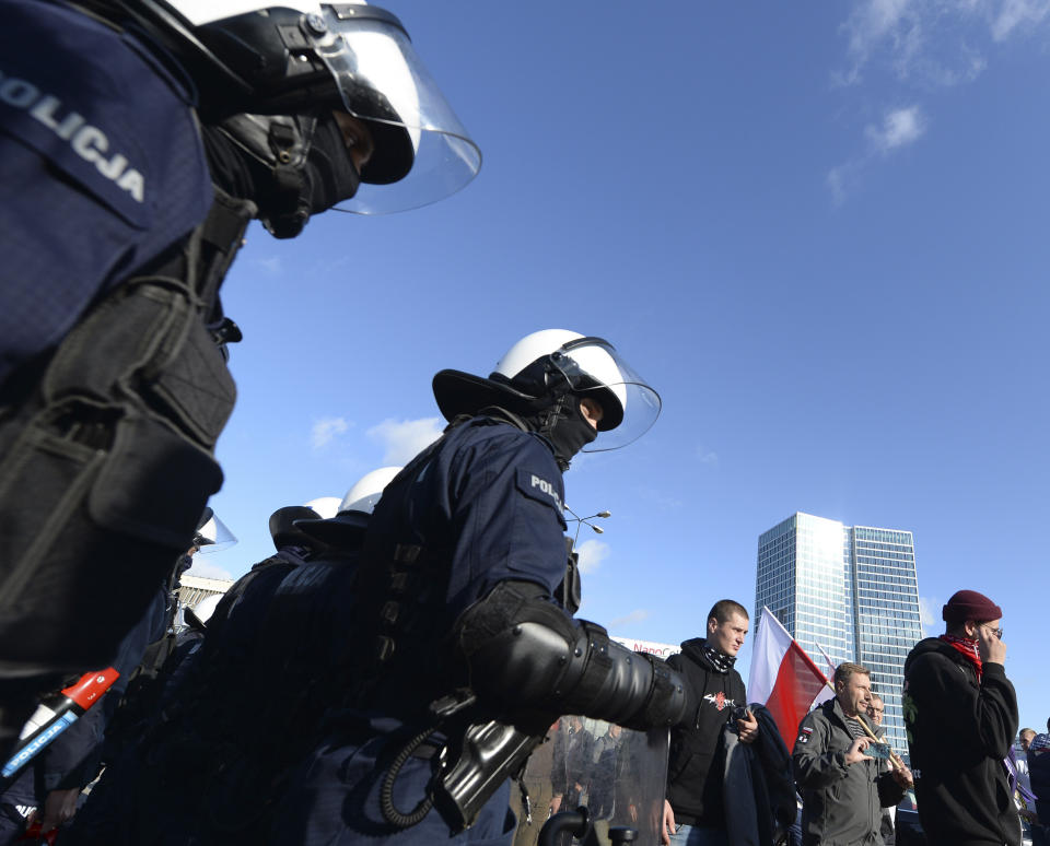 Polish police face protesters angry over new restrictions aimed at fighting the coronavirus pandemic, in Warsaw, Poland, Saturday, Oct. 24, 2020. The protesters included entrepreneurs, far-right politicians, football fans and vaccine opponents. The protesters, many wearing no protective masks, violated a new restriction on gatherings of more people. The clashes come amid rising social tensions and as new restrictions just short of a full lockdown took effect Saturday.(AP Photo/Czarek Sokolowski)