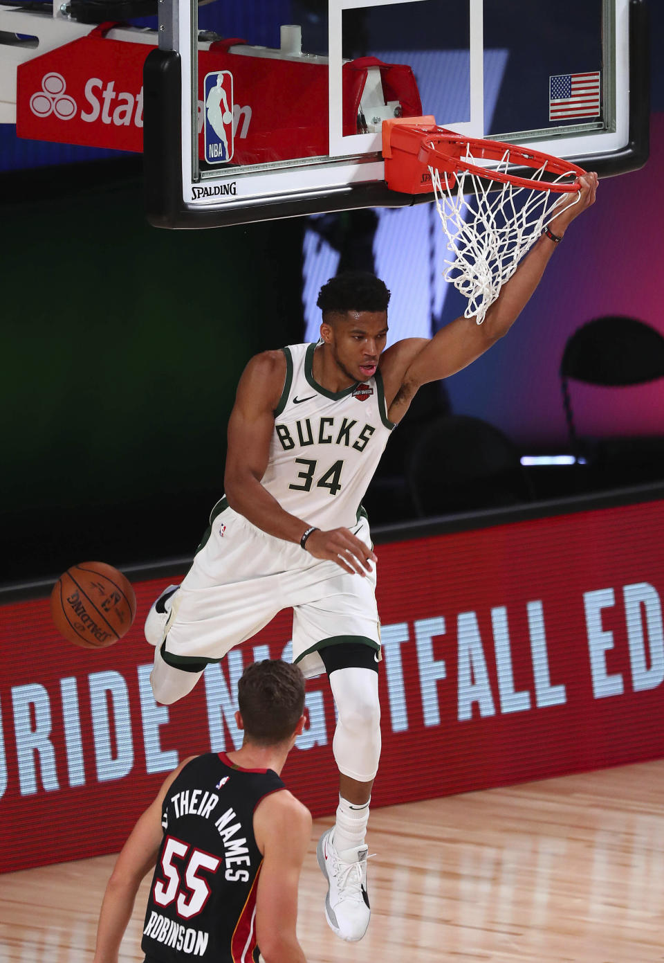 Milwaukee Bucks forward Giannis Antetokounmpo (34) scores a basket in front of Miami Heat guard Duncan Robinson (55) during the first half of an NBA basketball game Thursday, Aug. 6, 2020, in Lake Buena Vista, Fla. (Kim Klement/Pool Photo via AP)