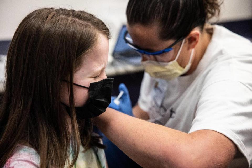 Bella Nissen, 10, left gets a dose of Pfizer’s COVID-19 vaccine from Amy Pinkston at the Novant East Mecklenburg vaccine clinic in Charlotte, on Nov. 4, 2021.