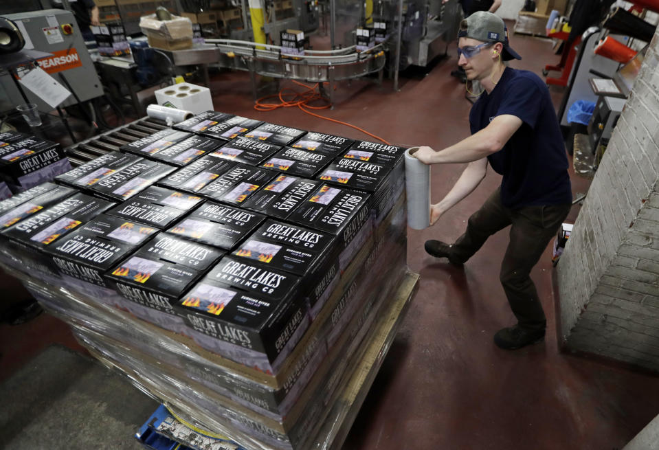 A worker shrink wraps cases of Burning River beer at The Great Lakes Brewing Company, Monday, June 17, 2019, in Cleveland. The "burning river" in the beer's name is inspired by the Cuyahoga River’s most famous fire. (AP Photo/Tony Dejak)