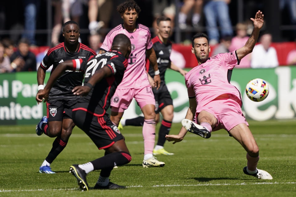 Inter Miami central midfielder Sergio Busquets, right, clears the ball during the first half of an MLS soccer match against DC United at Audi Field, Saturday, March 16, 2024, in Washington. (AP Photo/Nathan Howard)