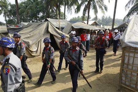 Police and volunteers walk as the government embarks on a national census at a Rohingya refugee camp in Sittwe, the capital of Rakhine State April 1, 2014. REUTERS/Soe Zeya Tun