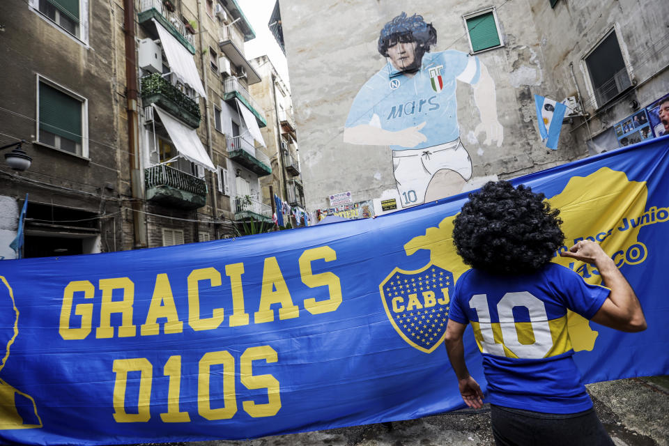 Fans pay their tribute on the occasion of the first anniversary of Diego Armando Maradona's death, in Naples, Italy, Wednesday, Nov. 24, 2021. Former Argentine soccer star Diego Maradona died of a heart attack on Nov. 25, 2020 at the age of 60, two weeks after being released from an Argentine hospital following brain surgery. (Alessandro Garofalo/LaPresse via AP)