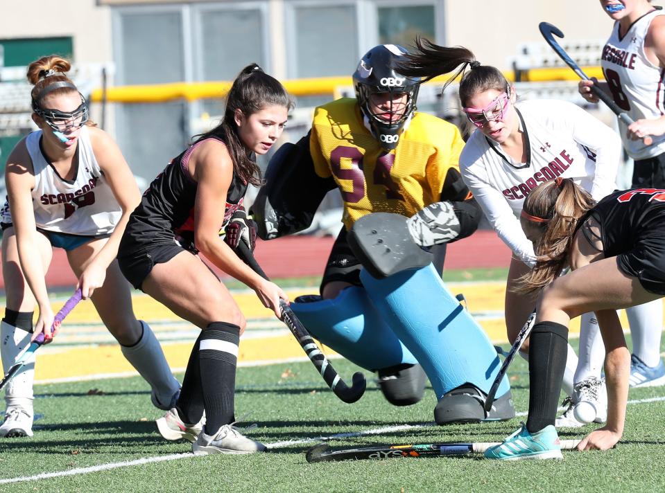 From left, Mamaroneck's Lizzie Astorina (2) puts pressure on Scarsdale goalie Gabriella Lopez (94) during the Section 1 Class A field hockey championship at Lakeland High School in Shrub Oak Oct. 29, 2022. Scarsdale won 3-2 in overtime.