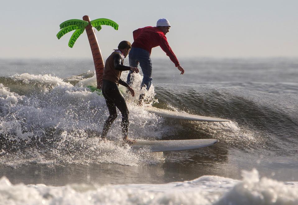 Participants surf during the third annual Rockaway Halloween surf competition at Rockaway Beach in the Queens borough of New York