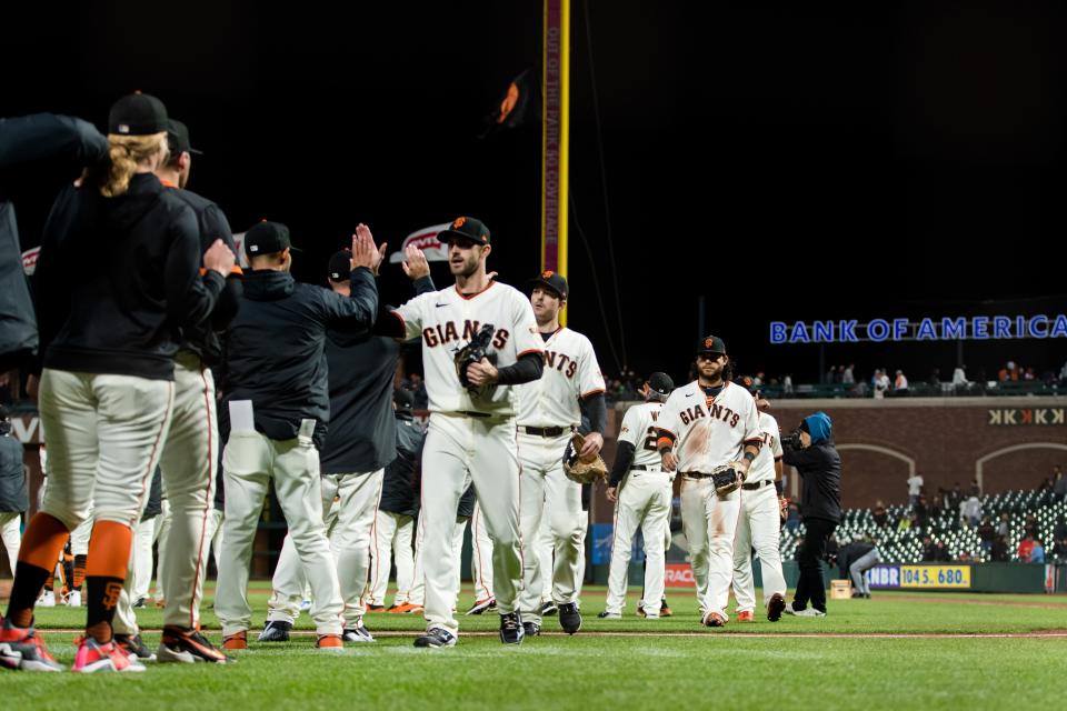 Giants players and coaches celebrate a win against the Cardinals.