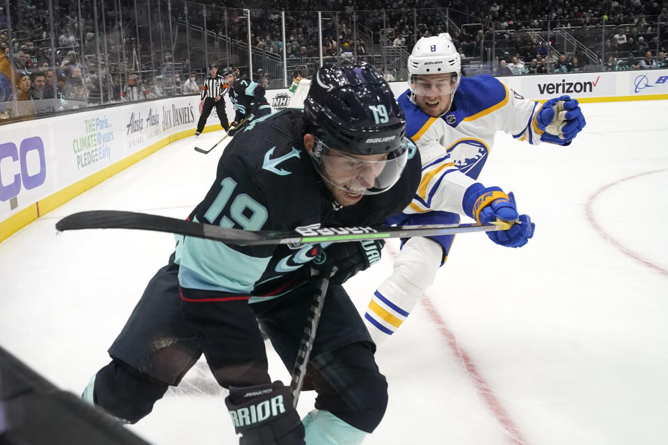 Buffalo Sabres' Robert Hagg, right, brings his stick across Seattle Kraken's Calle Jarnkrok as Jarnkrok tries to skate past during the first period of an NHL hockey game Thursday, Nov. 4, 2021, in Seattle. (AP Photo/Elaine Thompson)