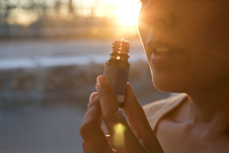 woman holding essential oil bottle