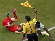 Switzerland's Stephan Lichtsteiner and Maynor Figueroa of Honduras (R) fall as the linesman raises the flag during their 2014 World Cup Group E soccer match at the Amazonia arena in Manaus June 25, 2014. REUTERS/Andres Stapff (BRAZIL - Tags: SOCCER SPORT WORLD CUP)