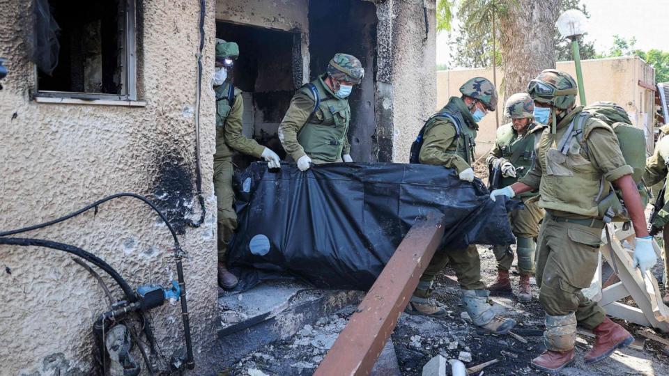 PHOTO: Israeli soldiers remove the body of a compatriot, killed during an attack by the Palestinian militants, in Kfar Aza, south of Israel bordering Gaza Strip, on Oct.10, 2023. (Jack Guez/AFP via Getty Images)