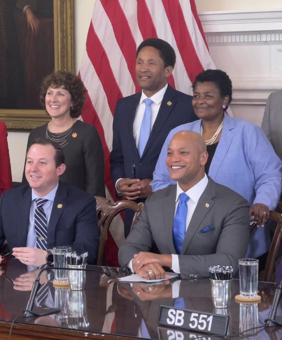 Maryland state Sen. Arthur Ellis, D-Charles, back row at center, poses next to other senators during a signing ceremony for the SERVE Act on April 24, 2023 in Annapolis. At the desk, at left, is Senate President Bill Ferguson, D-Baltimore, and, at right, Gov. Wes Moore.
