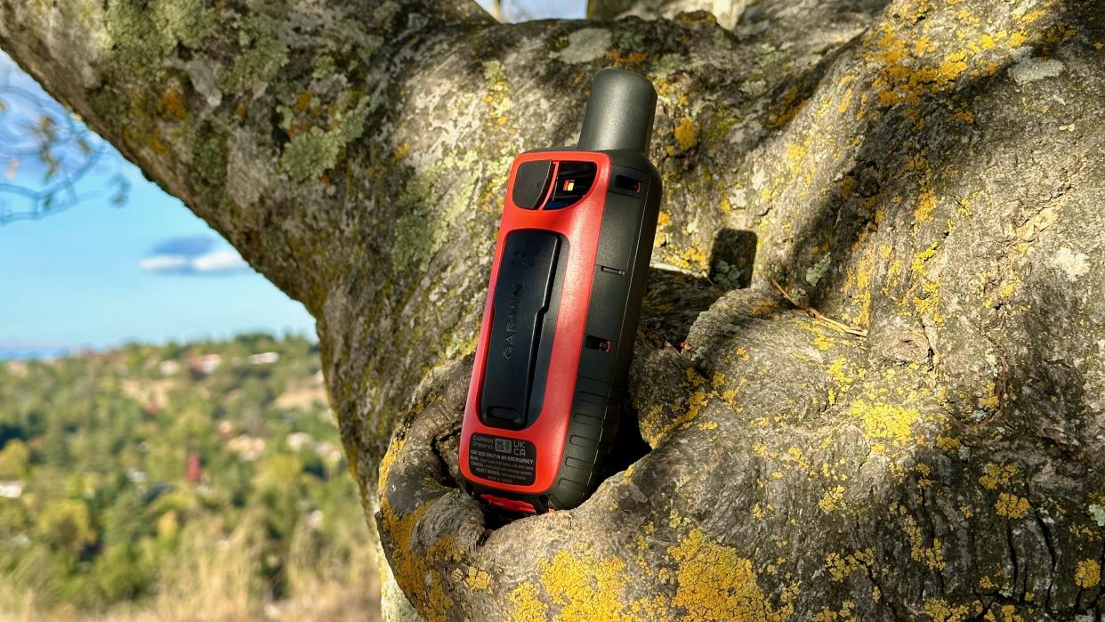  A close up of the Garmin GPSMAP 67i sitting on a tree. 