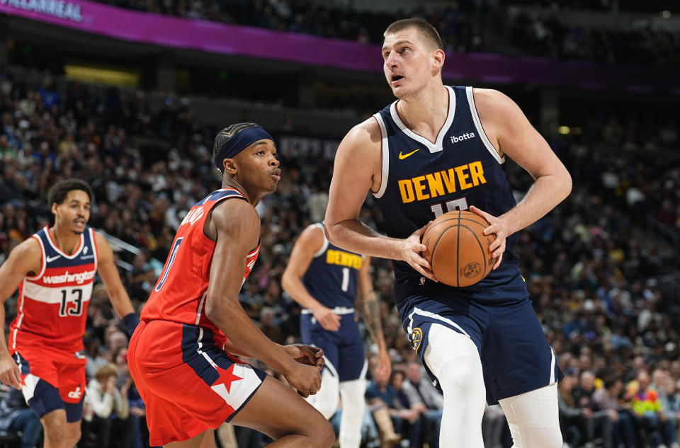 Denver Nuggets center Nikola Jokic, right, drives the lane as Washington Wizards guard Bilal Coulibaly defends in the second half of an NBA basketball game Thursday, Feb. 22, 2024, in Denver. (AP Photo/David Zalubowski)