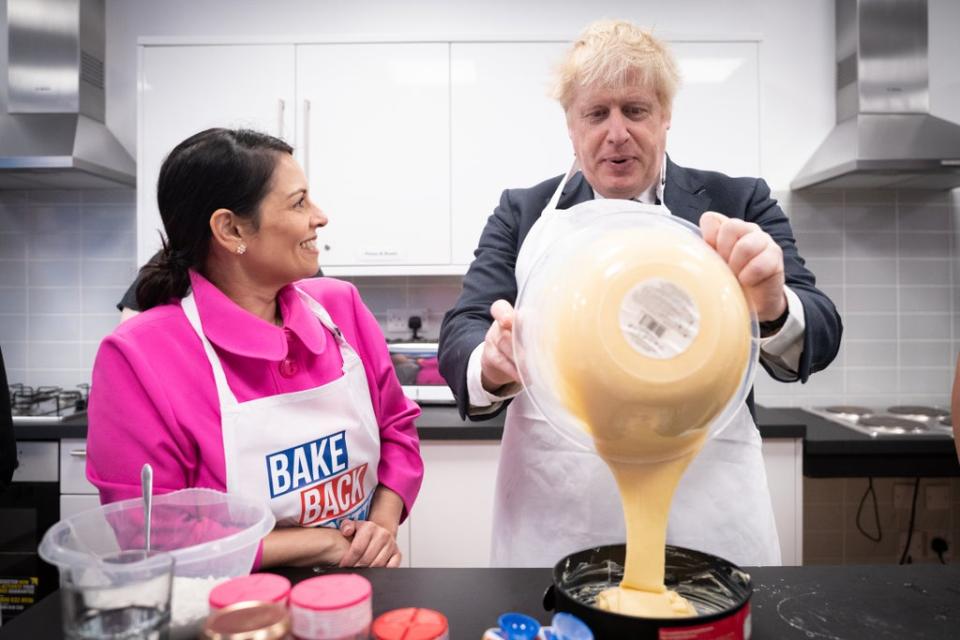 Home Secretary Priti Patel looks on as Prime Minister Boris Johnson tries his hand at baking during a visit to the HideOut Youth Zone, in Manchester (Stefan Rousseau/PA) (PA Wire)