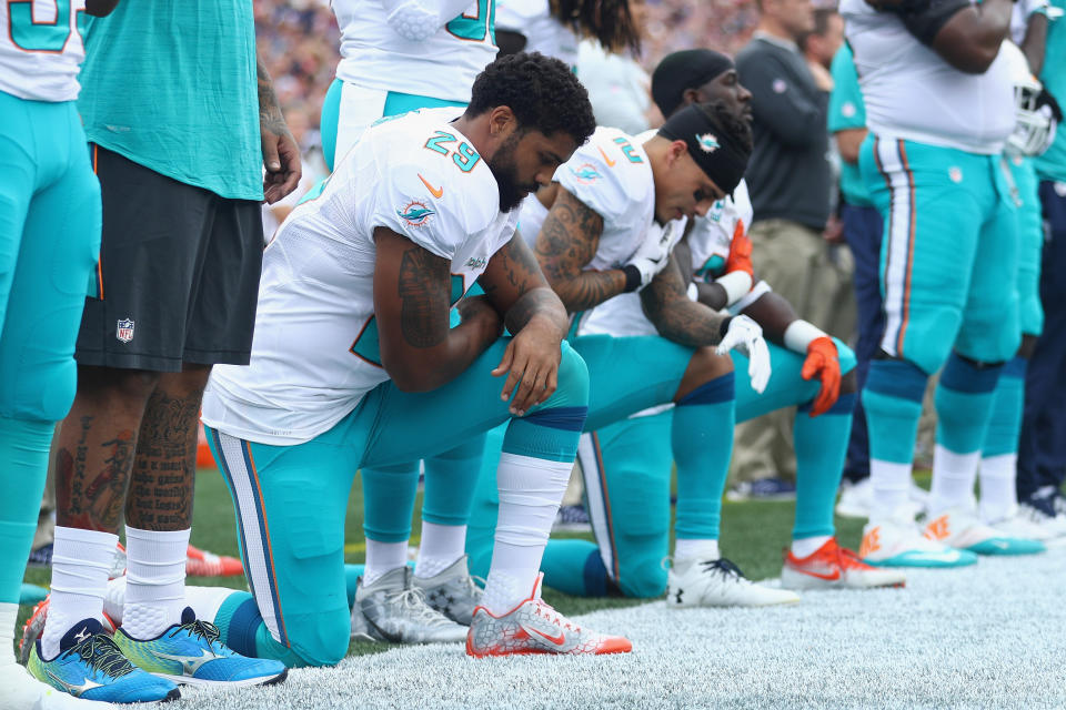 Arian Foster (No. 29), Kenny Stills (No. 10), and Michael Thomas (No. 31) of the Miami Dolphins kneel during the national anthem before the game against the New England Patriots at Gillette Stadium on Sept. 18, 2016. (Photo by Maddie Meyer/Getty Images)