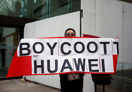 Max Wang, from China and now living in Vancouver, holds a placard during an extradition hearing for Huawei Technologies Co Chief Financial Officer Meng Wanzhou at the B.C. Supreme Court in Vancouver, British Columbia, Canada, March 6, 2019. REUTERS/Lindsey Wasson