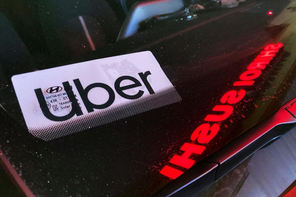 An Uber sign displayed in a car window.