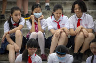 Students wearing face masks to protect against the coronavirus sit on steps at the Temple of Heaven in Beijing, Saturday, July 18, 2020. Authorities in a city in far western China have reduced subways, buses and taxis and closed off some residential communities amid a new coronavirus outbreak, according to Chinese media reports. They also placed restrictions on people leaving the city, including a suspension of subway service to the airport. (AP Photo/Mark Schiefelbein)